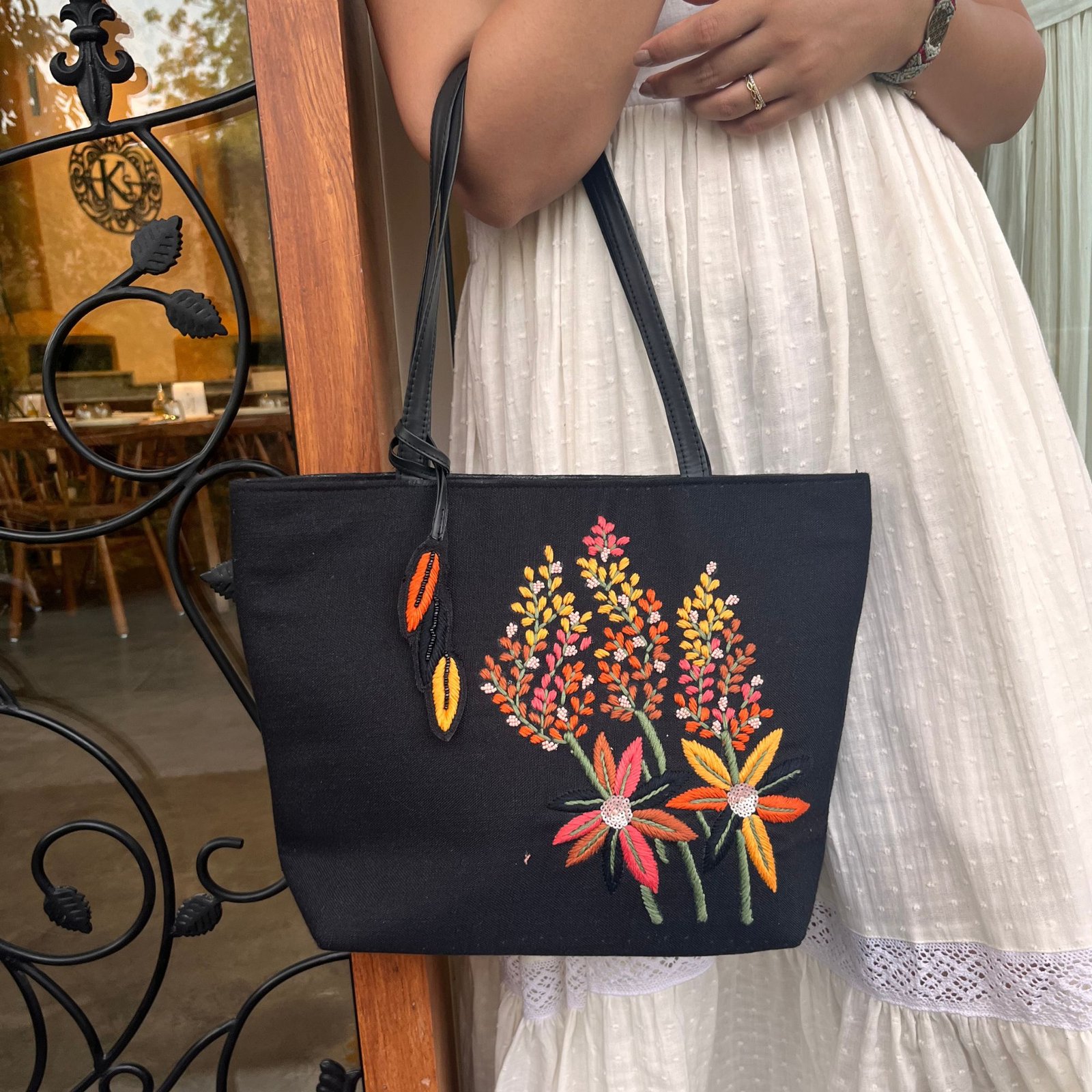 Black embroidered tote bag carried by model for everyday styling Black embroidered tote bag carried by model for everyday styling